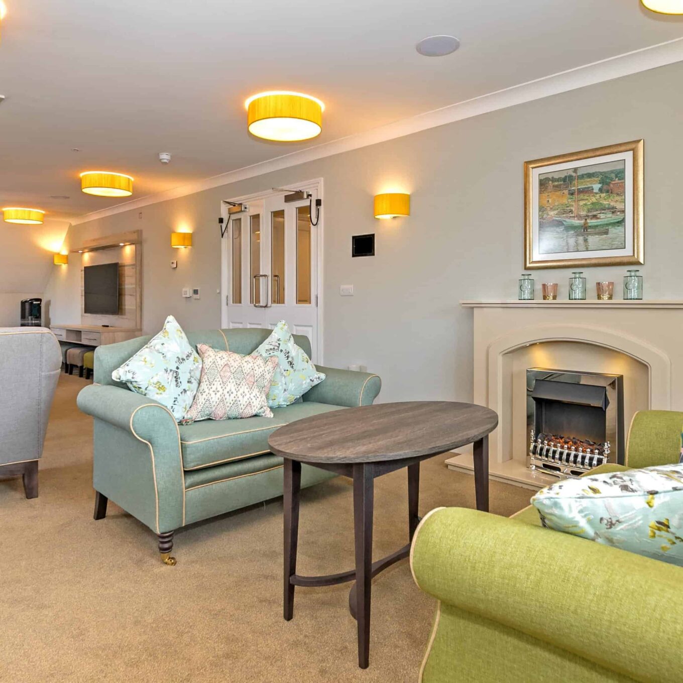 Communal room with fireplace at Oakland Beechwood Grove Care Home in Eastbourne