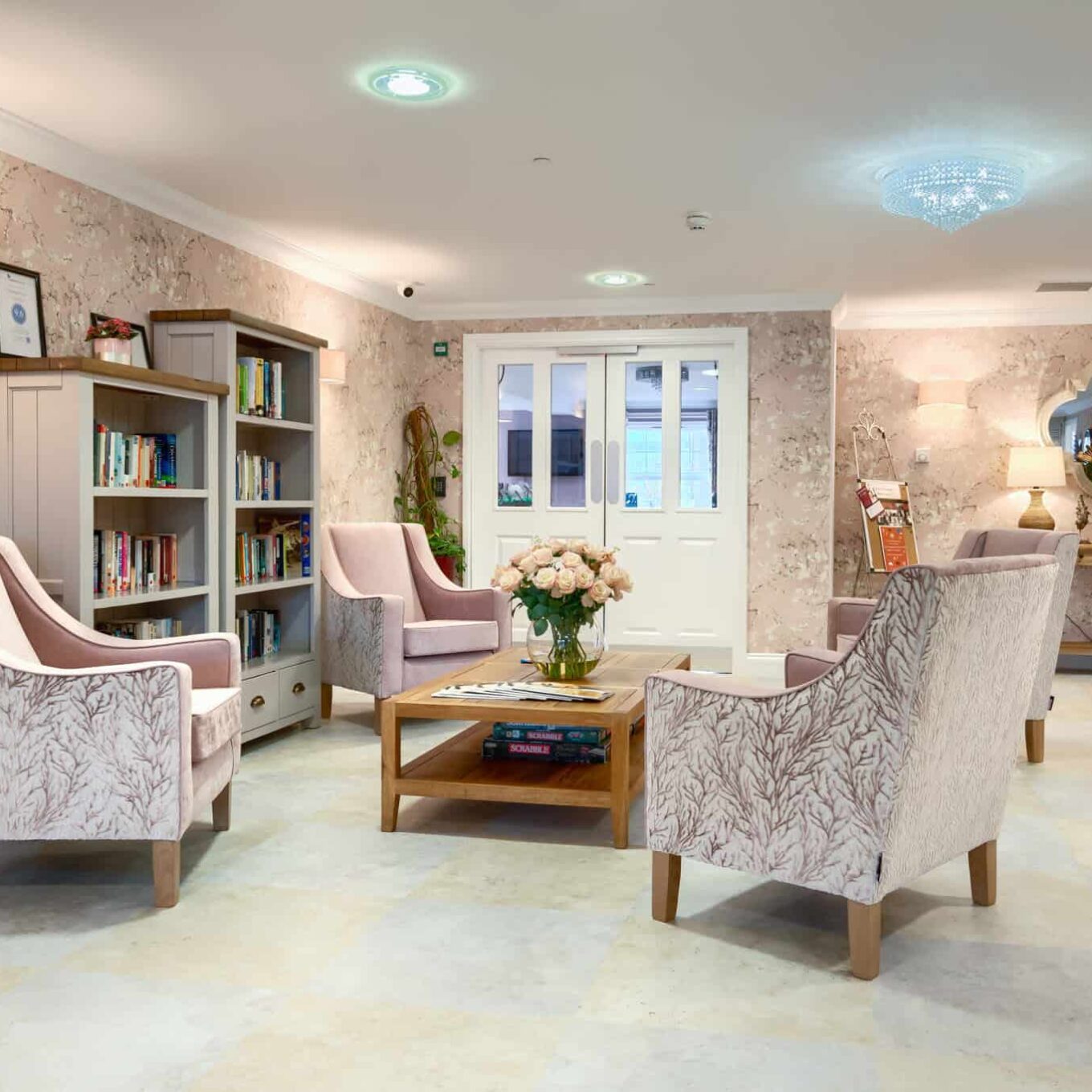 Seating area with book cabinet at Woodland Grove Care Home in Essex