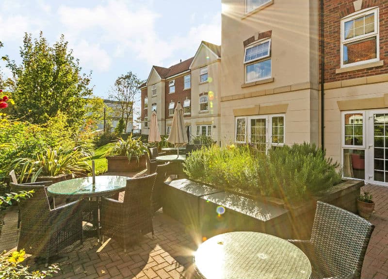 Outdoor seating area with table and chairs at Woodland Grove Care Home in Loughton