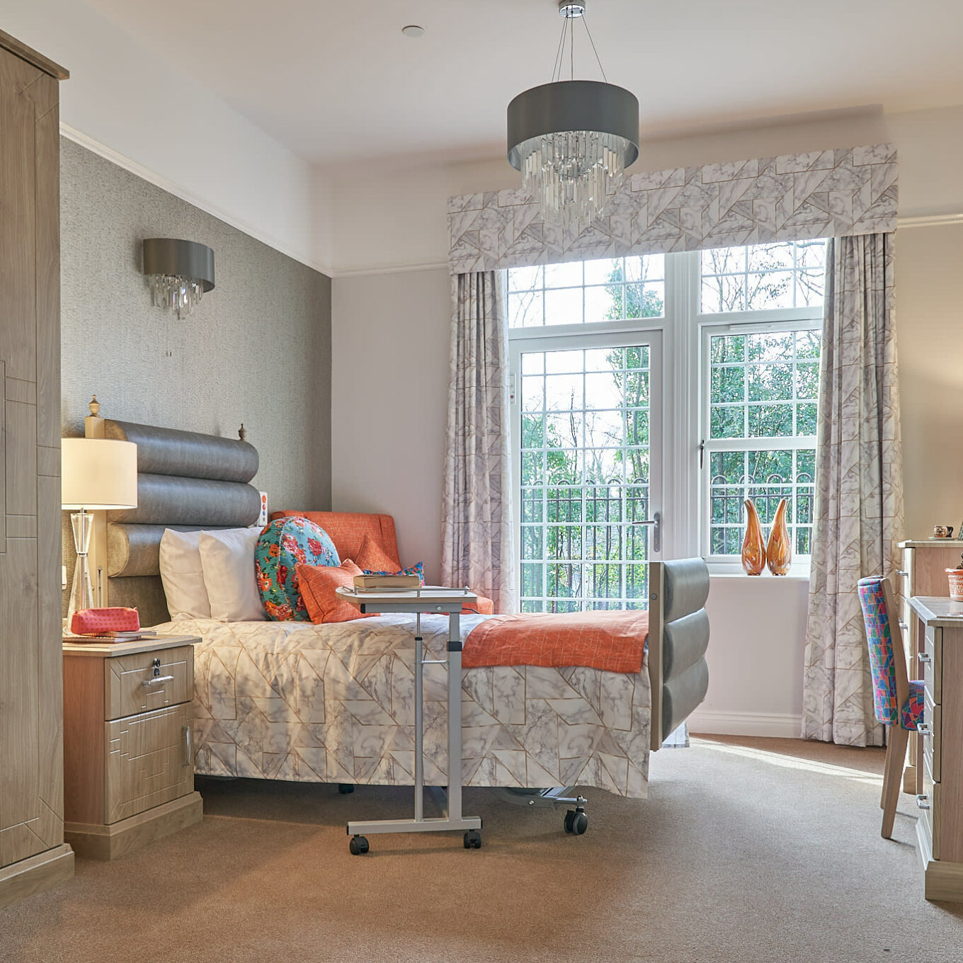 Bedroom with chandelier at Oakland Care Home in Chigwell