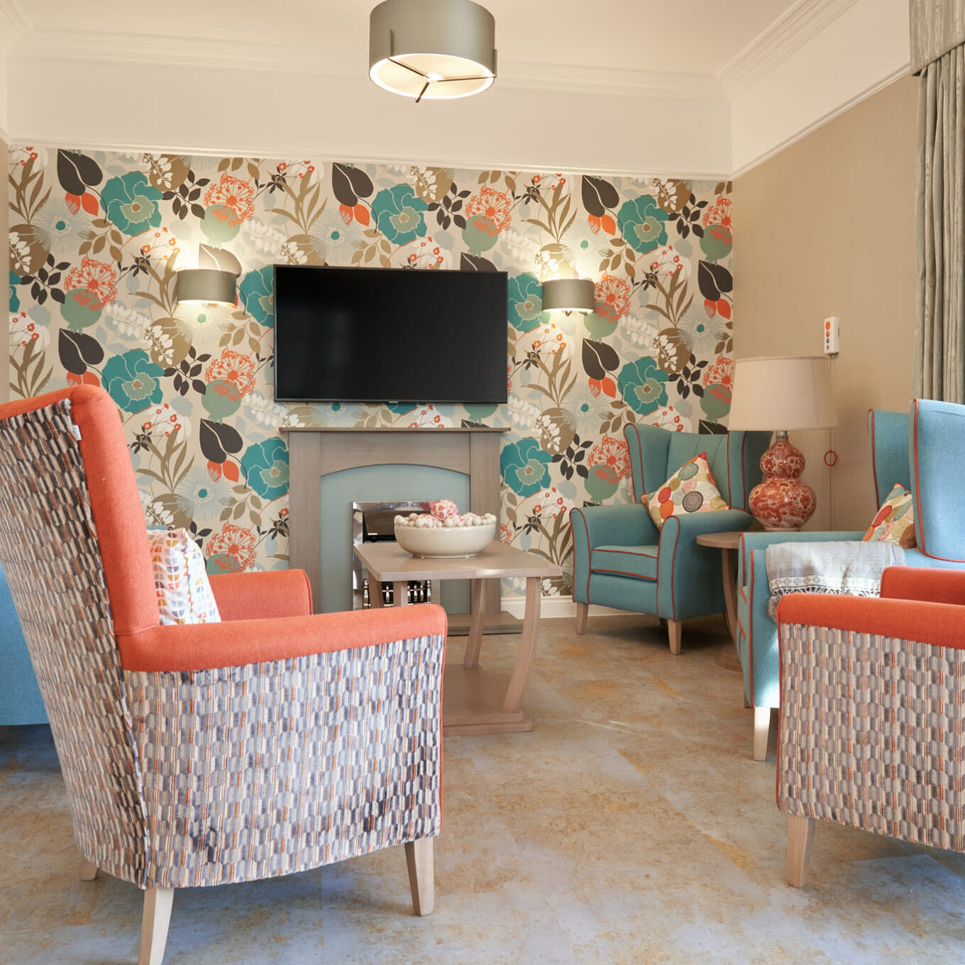 Lounge room with flowery wallpaper at Lambwood Heights Care Home