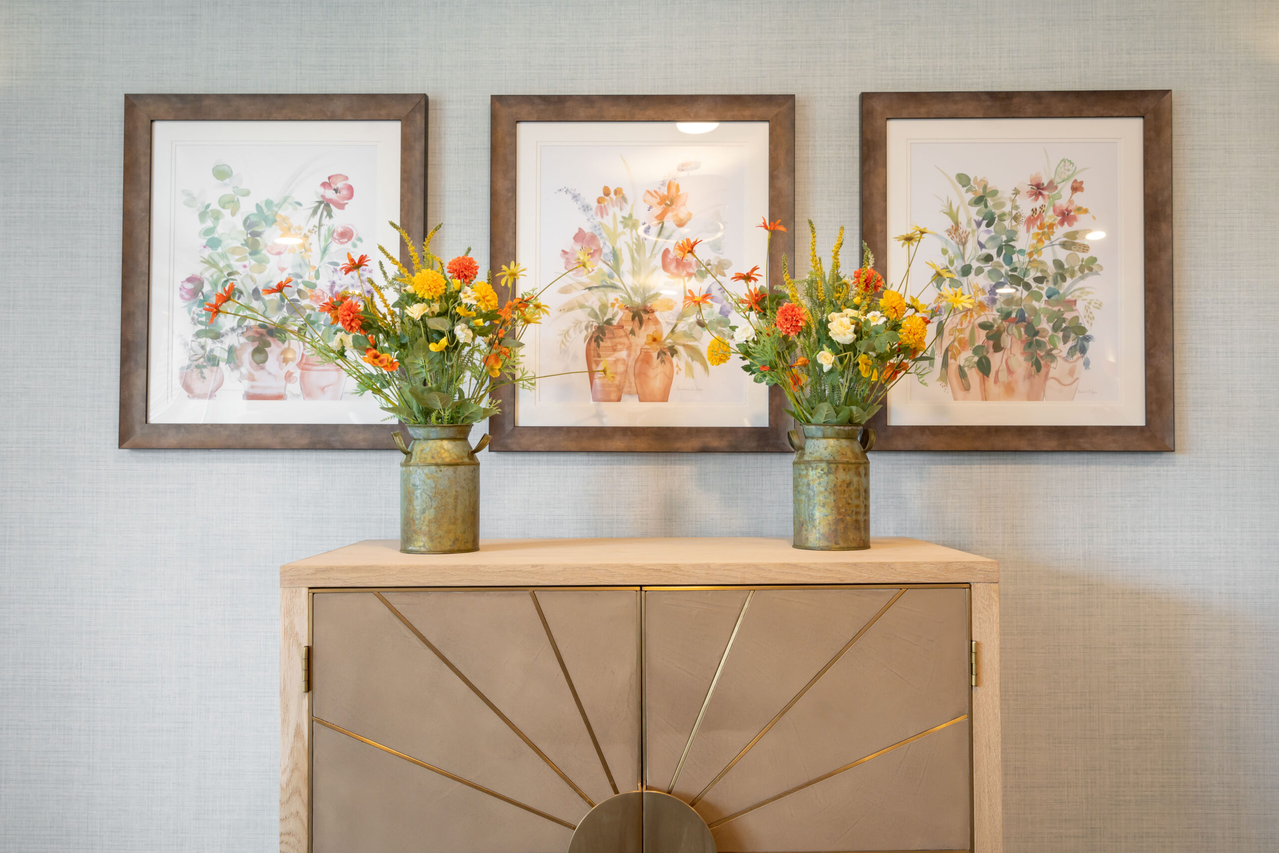 Flowers on cabinet with pictures of flowers on wall at Birchwood Heights Care Home in Swanley