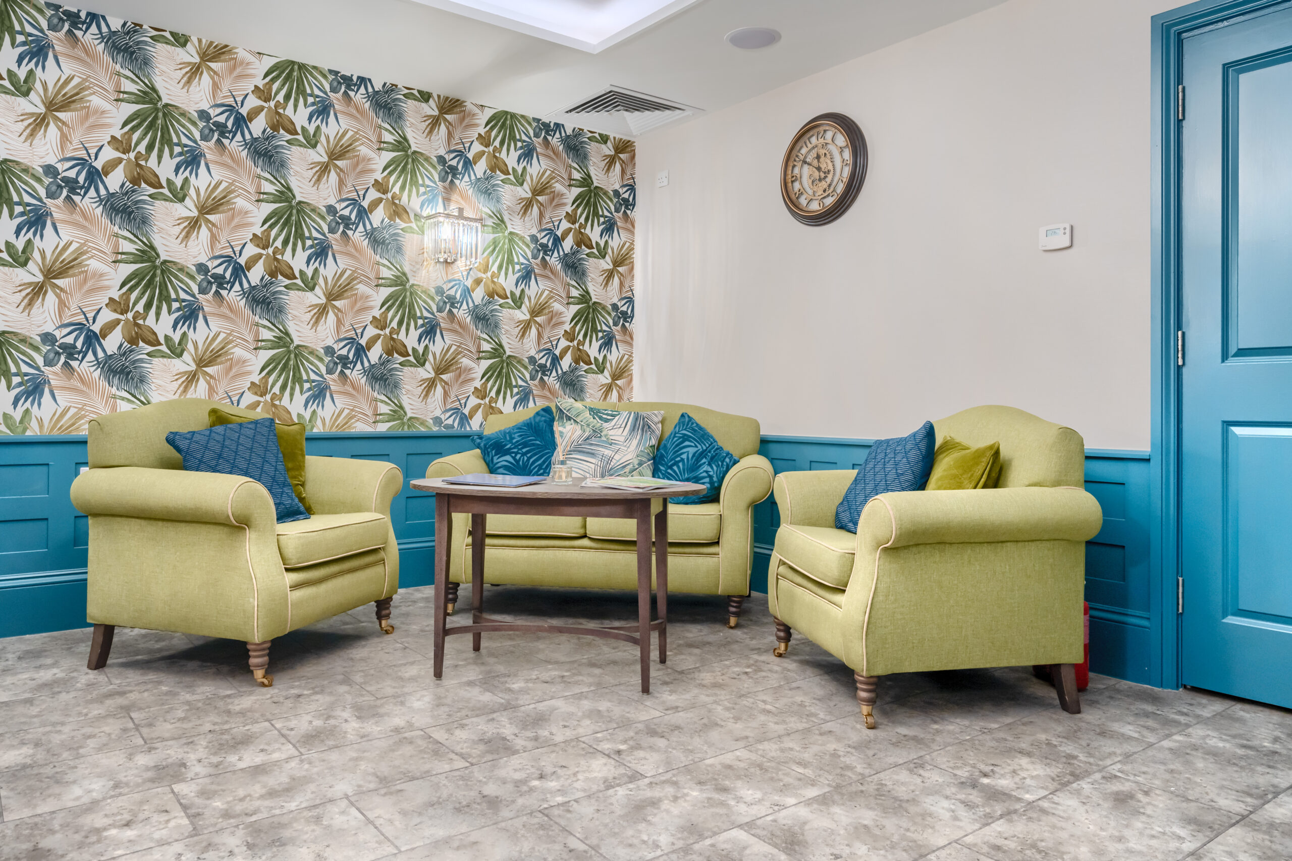 Beechwood Grove Care Home seating area with flowery wallpaper and clock on wall